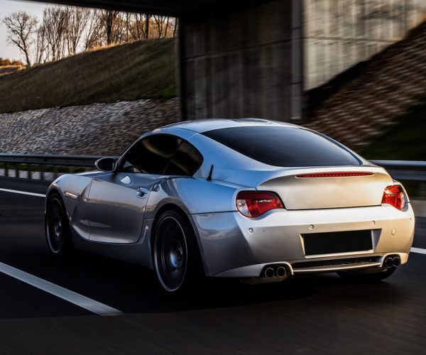 back-side-view-metallic-silver-coupe-road_114579-4049a